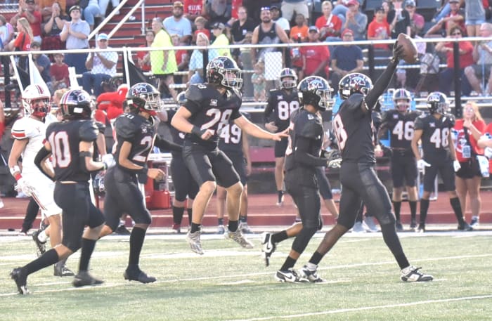 Mustang players celebrate after teammate Zach Warren (with ball) comes up with an interception during the Broncos' win against Yukon on Sept. 22, 2023.